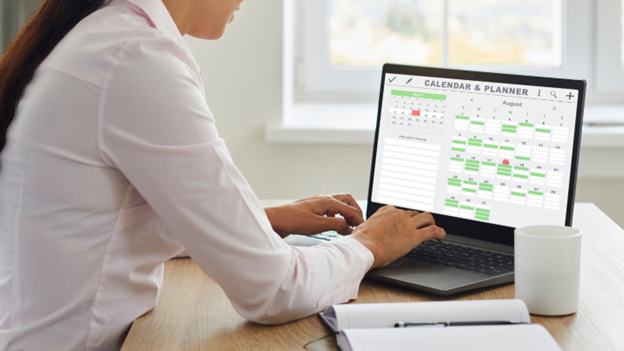 An image of a woman scheduling tasks using a laptop