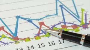A pen resting on a colorful line graph, showcasing fluctuating data points