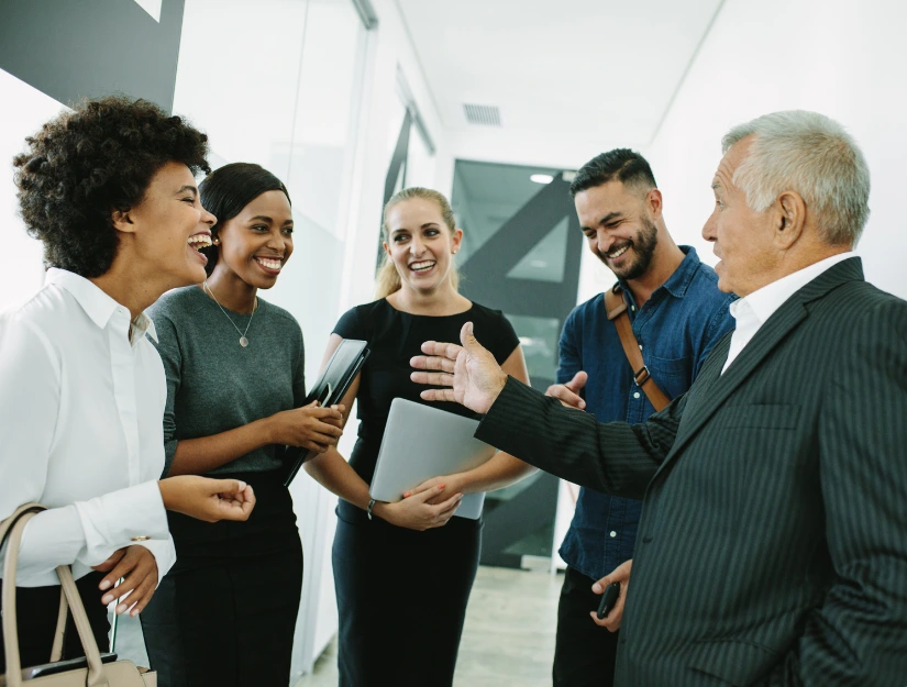 A group of professionals engage in a conversation in a modern office environment