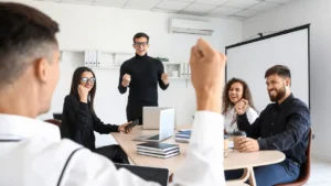 A business meeting in progress, with a presenter engaging an attentive group around a table, showcasing active discussion and participation.