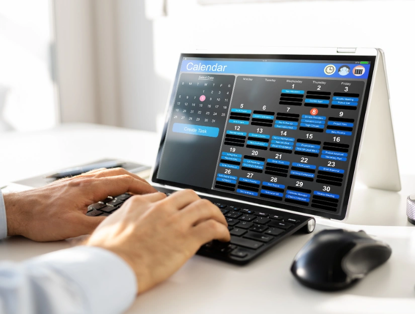 A person uses a keyboard to interact with a digital calendar on a tablet, managing tasks and viewing dates for November.