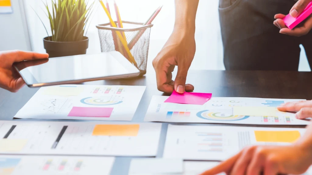 A person putting sticky notes on a analytics report
